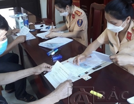 Cán bộ chiến sĩ phòng CSGT làm thủ tục cấp đổi giấy đăng ký xe cho người dân tại xã Quân Hà, huyện Bạch Thông