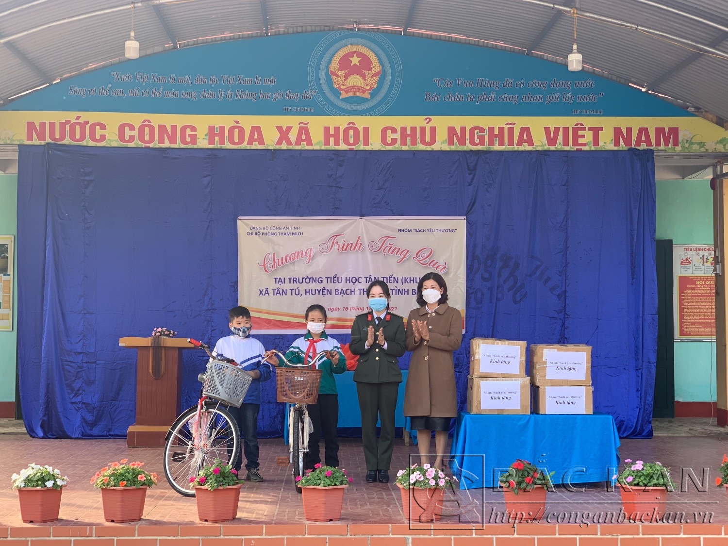 Đại diện Chi bộ phòng Tham mưu tặng quà cho nhà trường và xe đạp cho 2 em học sinh