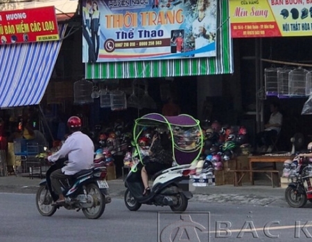 1 mô tô được gắn mái che tham gia giao thông tại khu vực Chợ Bắc Kạn