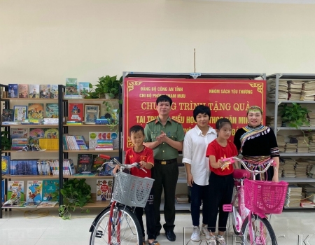 Trung tá Vũ Đức Toàn, phó trưởng Phòng Tham mưu và đại diện nhóm " Sách yêu thương" tặng xe đạp cho 2 em học sinh