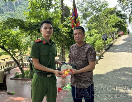 Đồng chí Nguyễn Huy Cường (áo nâu) bàn giao tài sản nhặt được cho Công an thị trấn Đồng Tâm