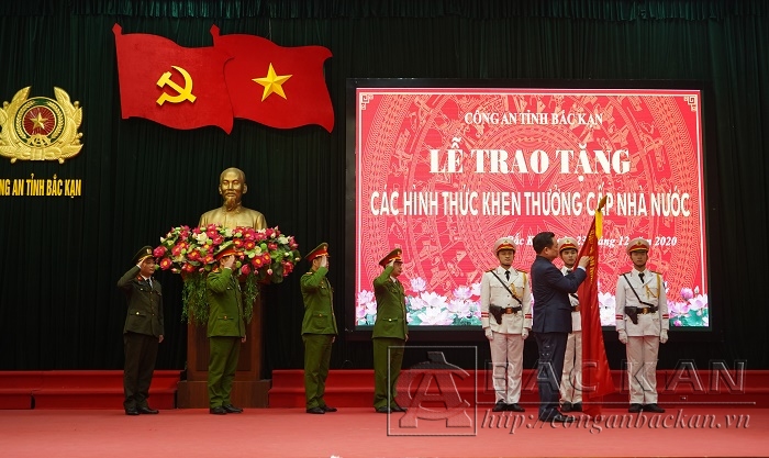 Đồng chí Hoàng Duy Chinh, Bí Thư Tỉnh ủy Bắc Kạn gắn lên cờ truyền thống và trao Huân chương Chiến công hạng Ba cho Công an huyện Bạch Thông