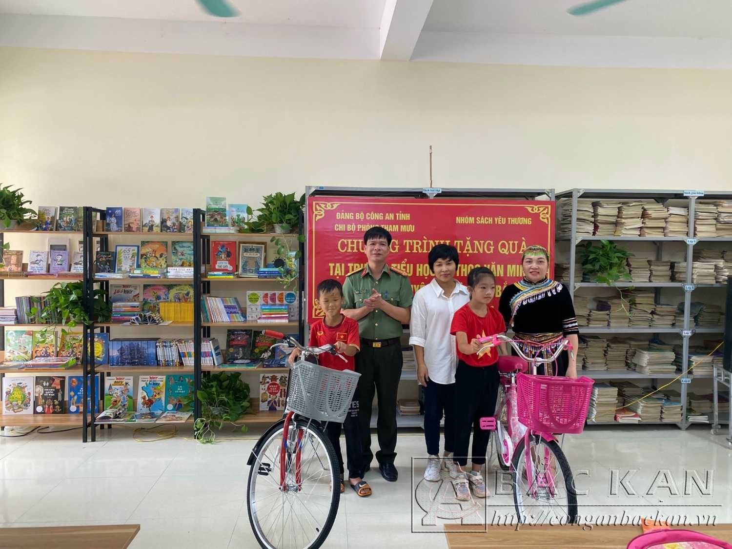 Trung tá Vũ Đức Toàn, phó trưởng Phòng Tham mưu và đại diện nhóm " Sách yêu thương" tặng xe đạp cho 2 em học sinh