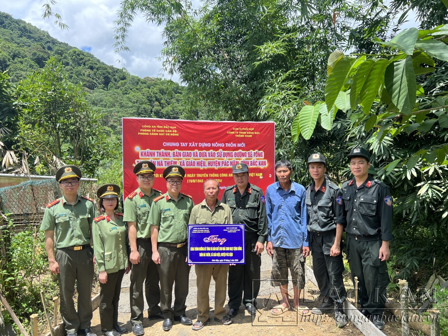 Lãnh đạo Phòng Cảnh sát Cơ động, Phòng Tổ chức cán bộ gắn biển khánh thành công trình đường bê tông và trao quà tặng nhà sinh hoạt cộng đồng thôn Nà Thiêm