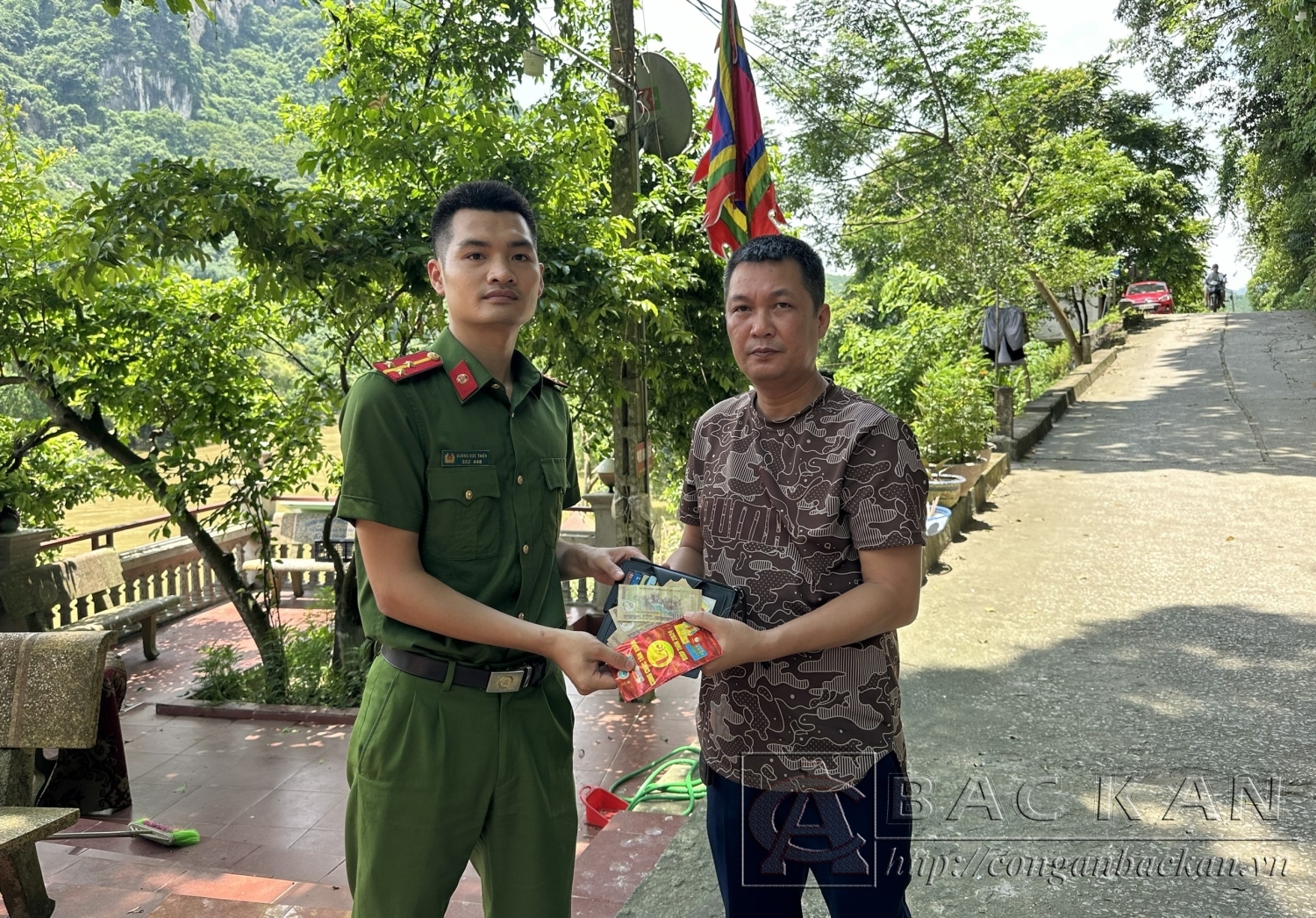 Đồng chí Nguyễn Huy Cường (áo nâu) bàn giao tài sản nhặt được cho Công an thị trấn Đồng Tâm